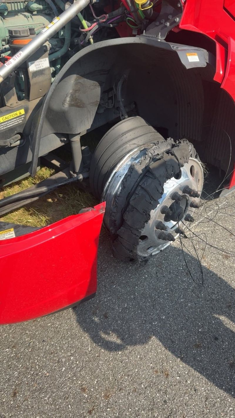 A damaged steer tire on a red truck.